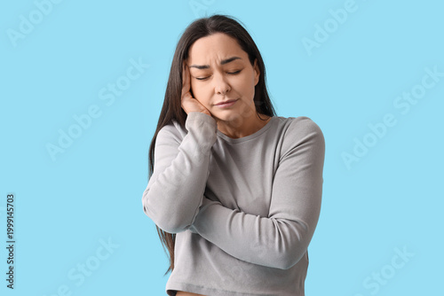 Young woman feeling bad on blue background. Brain cancer concept