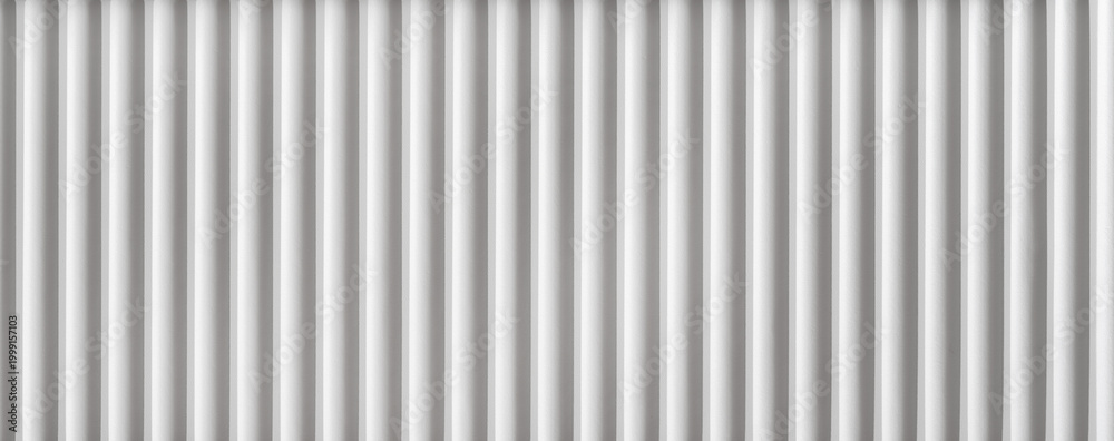 Fototapeta premium Lines of white vertical panels in a modern indoor setting creating a pattern on the wall. setting is likely for modern architecture.