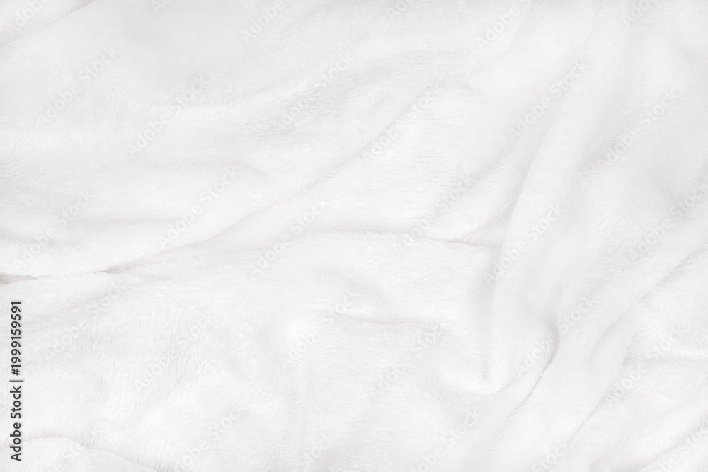 Obraz premium soft white blanket is spread out on a flat surface, its soft texture visible through it. It lies comfortably and feels warm.