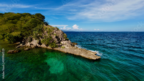 Bilde på lerret Tropical rocky coastline with clear turquoise water and lush vegetation