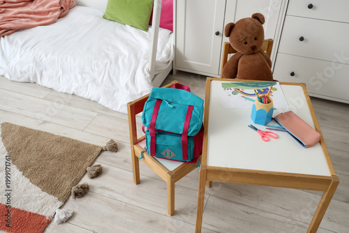 Backpack on chair in children's bedroom interior