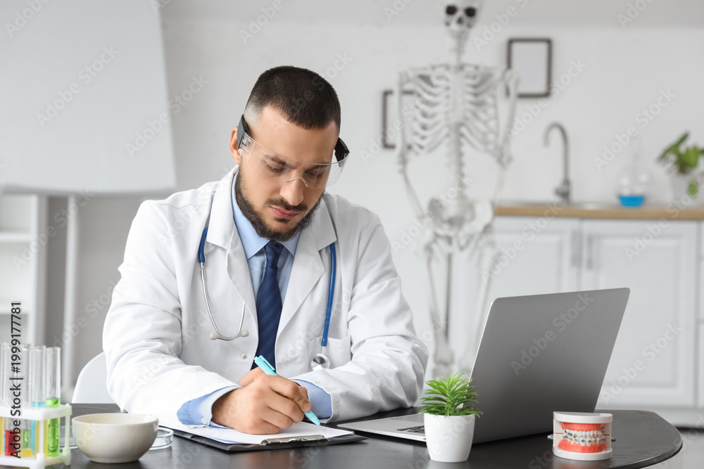 Fototapeta premium Male doctor in AR glasses writing on clipboard at office