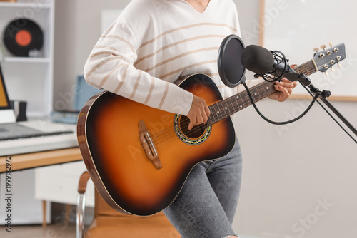 Young woman playing guitar ...