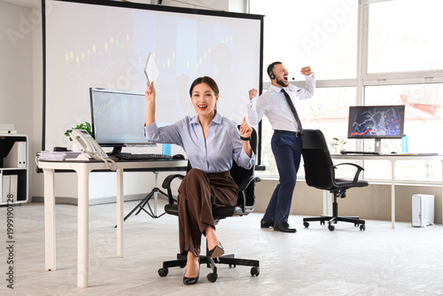 Happy female Asian trader s...