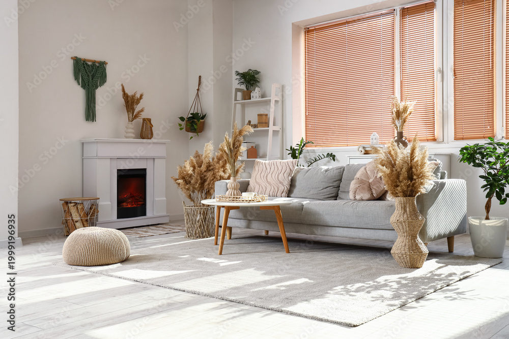 Fototapeta premium Interior of stylish living room with cozy grey sofa, coffee table and pampas grass