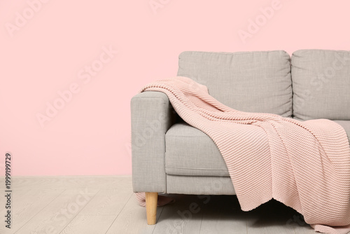 Beige sofa with pink knitte...