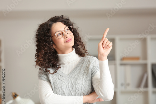 Young woman pointing at som...