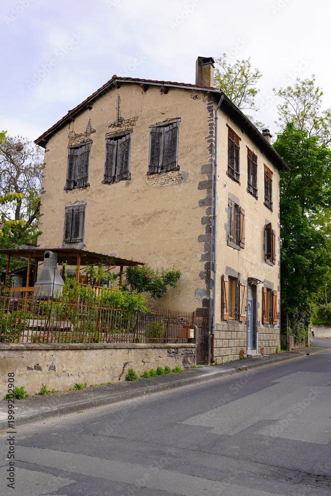Obraz premium Old abandoned house with boarded windows on quiet street, rustic European architecture
