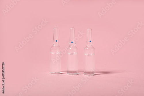 Glass ampules on pink backg...