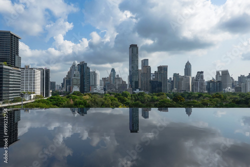 A panoramic view of Bangkok, Thailand, showing tall buildings surrounding Lumpini Park, reflecting Bangkok's green city image. Taken at Dusit Central Park, a favorite landmark for tourists and travele