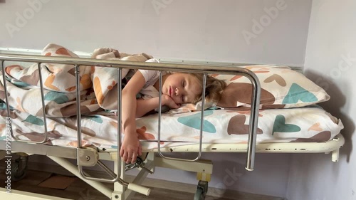 Baby sleeps in bed in hospital room. Little baby in hospital