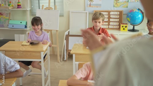 Schoolboy standing and answering in front of class while classmates listen, representing communication and classroom learning
