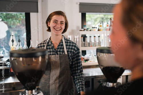 Smiling barista in cafe wea...