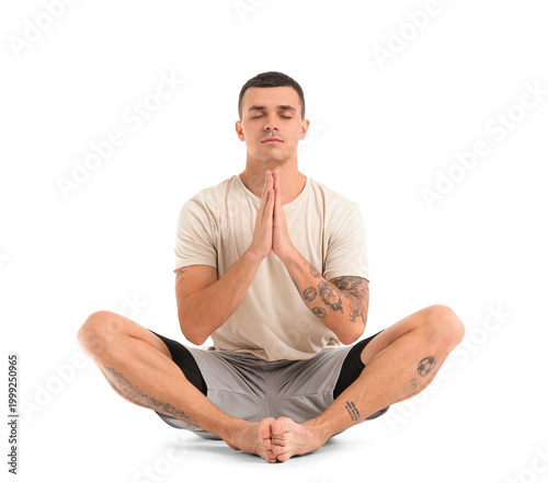 Young man meditating on whi...
