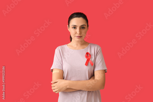 Photos Young woman with crossed arms and red ribbon on color background