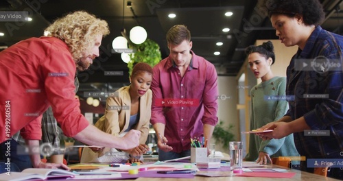 Leaning team pointing, sorting paper, sticky notes, smartphone in office, wearing red jacket