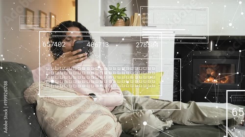 Non-binary person reclining on couch, tapping smartphone and causing animated AR data HUDs to shift