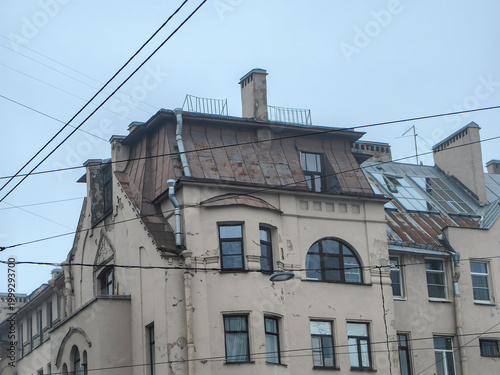 Old European apartment buildings with weathered roofs and overhead wires