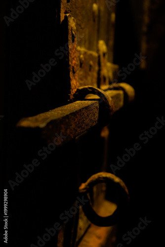Rusty metal latch with padlock in dark moody light
