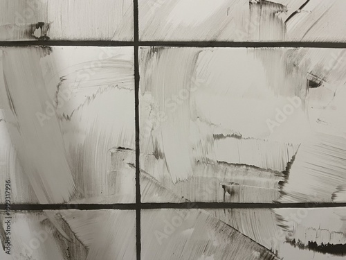 An authentic capture of the tiling process showing fresh, wet grey grout roughly smeared across the surface of white ceramic wall tiles. The uneven, sweeping strokes and thick patches of construction