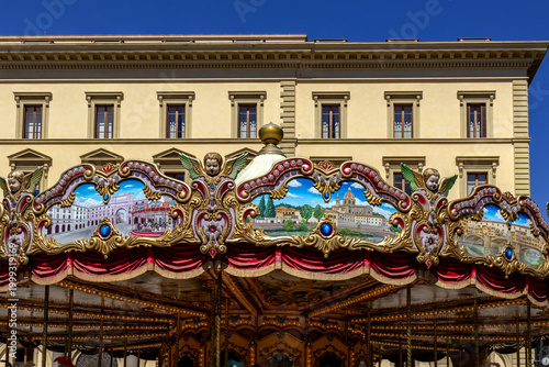 Carousel With Decorative Panels Angelic Sculptures Painted Scenes Under A Blue Sky In Front Of An Old Building In The Historic City Centre On A Sunny Day