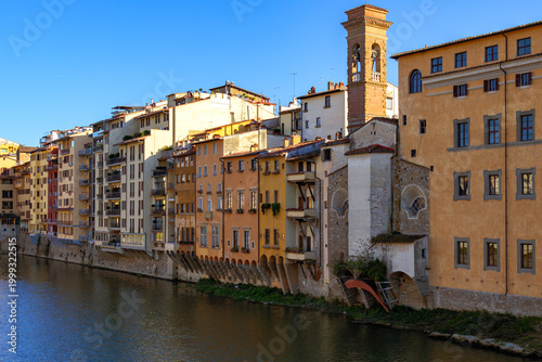 Iconic Florence Italy View Of Old Bridge Ponte Vecchio With Traditional Colorful Buildings Reflected In Arno River Under Clear Blue Sky At Sunset