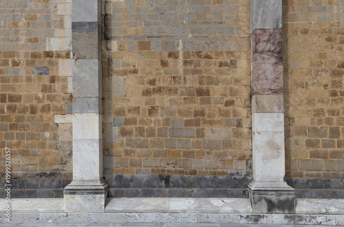 Ancient Stone Wall with Two Distinct Pillars Showing Variegated Color Patterns and Weathering