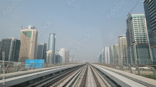 Dubai, UAE - October 28, 2025: Metro train tracks leading through a modern city skyline on a clear day
