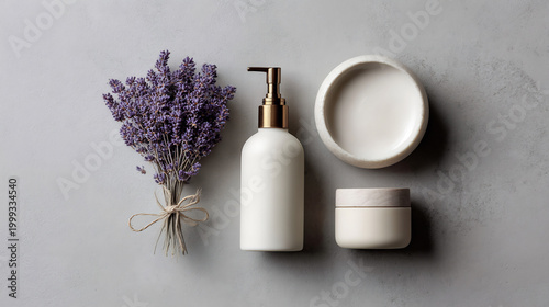 Top view of natural lavender skincare products on a grey background: lotion, cream, and oil for beauty and spa.