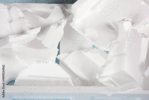 Styrofoam Sheets of different shapes on blue background. Pieces of white styrofoam close up