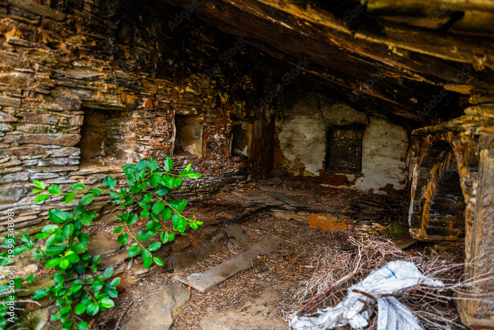 Naklejka premium Karavostamo in Ikaria island, Greece abandoned mountain village stone home house interior with window fireplace at old ancient town