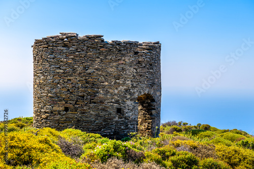 Watchtower tower ruins at Perdiki village on Ikaria island, Greece cityscape of small town with houses at longevity blue zone