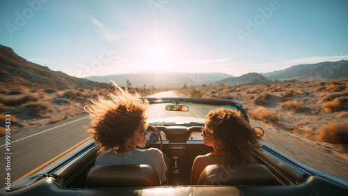 Two friends on a road trip, driving a convertible through an open desert road, sun shining, natural wind, carefree smiles, adventure and freedom vibe, panoramic landscape of the desert