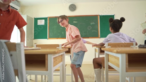 Diverse students writing together on chalkboard in classroom, representing collaborative learning and teamwork