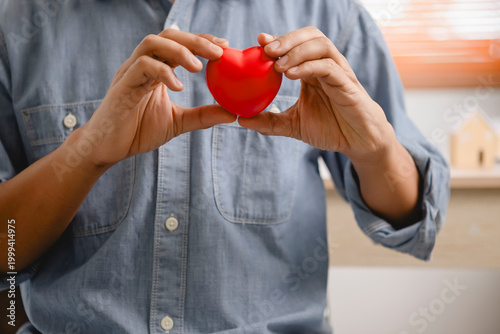 Foto Person Holding Red Heart-Shaped Object in Cozy Indoor Setting