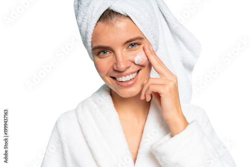 Quadro su tela Closeup of woman in towel on head applying lifting cream on her clean face after