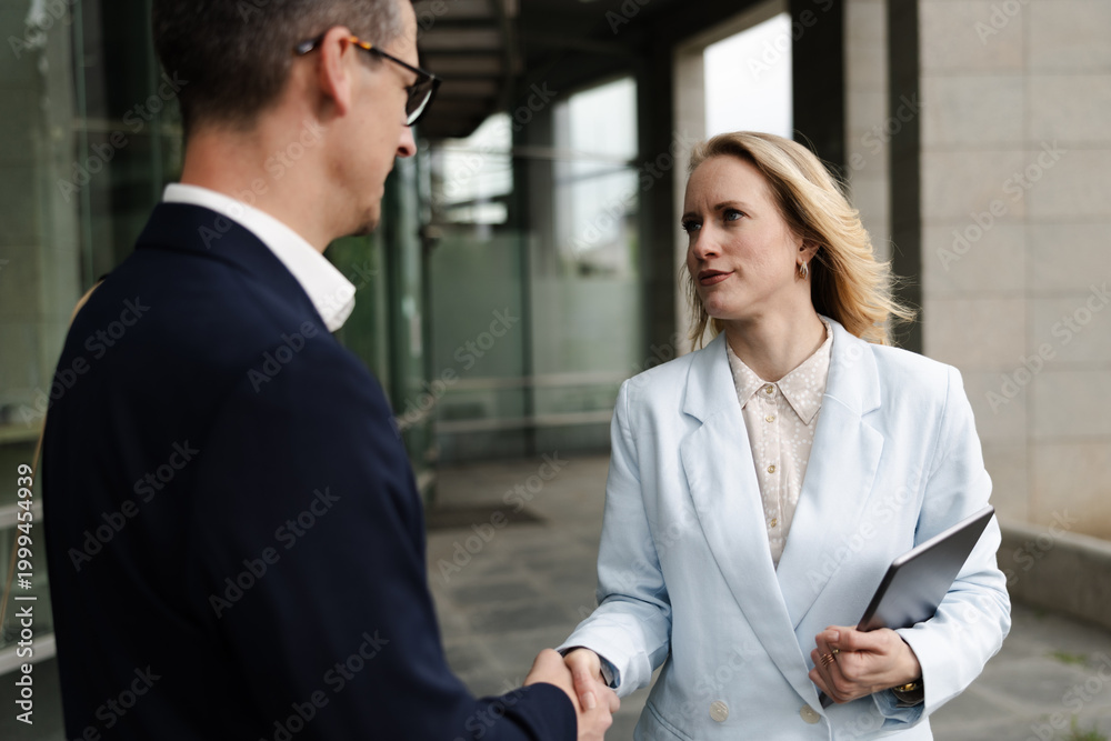 Fototapeta premium Business Meeting Between Two Professionals Outside an Office Building on a Sunny Day in the City