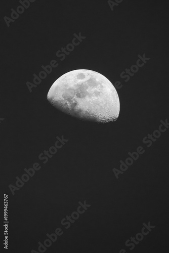 A sharp, telephoto astrophotography image of a waning gibbous moon against a deep black, texture-free night sky, highlighting intricate lunar craters and maria details.
