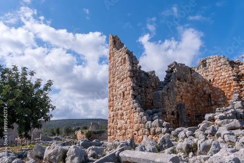 Bilde på lerret Ancient stone ruins of a sun-drenched fortification wall stand against a clear blue sky in a Mediterranean landscape
