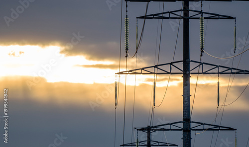 Foto Power lines stand tall against a golden sky