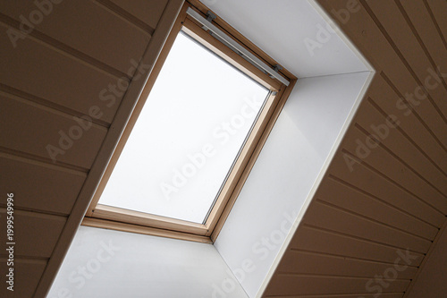 Obraz na plátně rectangular skylight with a light wooden frame set into a sloped ceiling