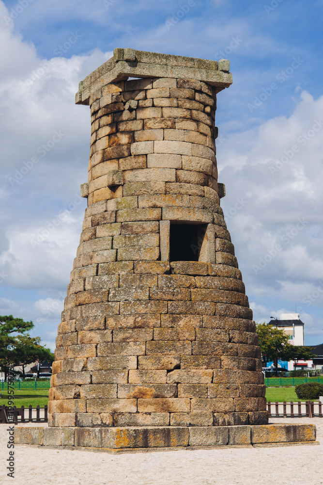 Obraz premium Gyeongju, South Korea, Cheomseongdae astronomical Observatory, Silla dynasty ancient stone tower, North Gyeongsang province, Gyeongju city view, Yeongnam region, in a sunny day with a blue sky