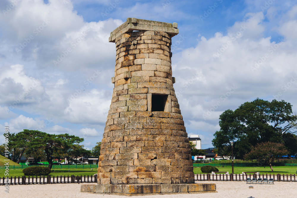 Obraz premium Gyeongju, South Korea, Cheomseongdae astronomical Observatory, Silla dynasty ancient stone tower, North Gyeongsang province, Gyeongju city view, Yeongnam region, in a sunny day with a blue sky
