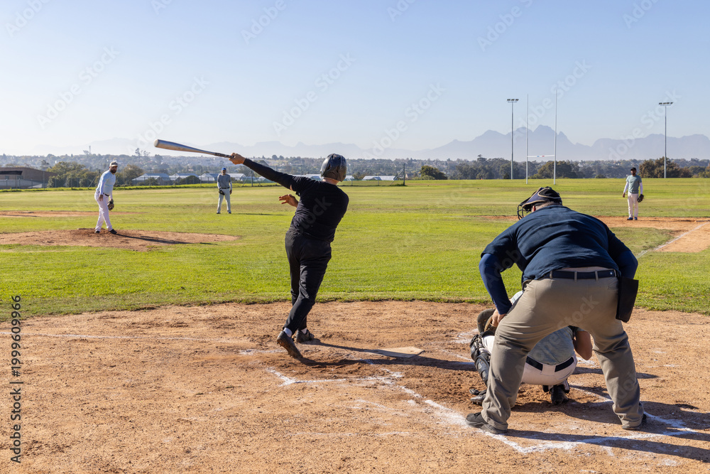 Obraz premium Baseball pitcher delivering pitch, batter swinging metal bat, following through to drive outfield