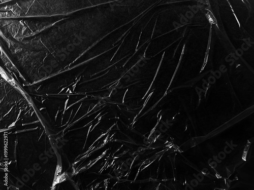 фотографія Wrinkled plastic wrap texture on a black background