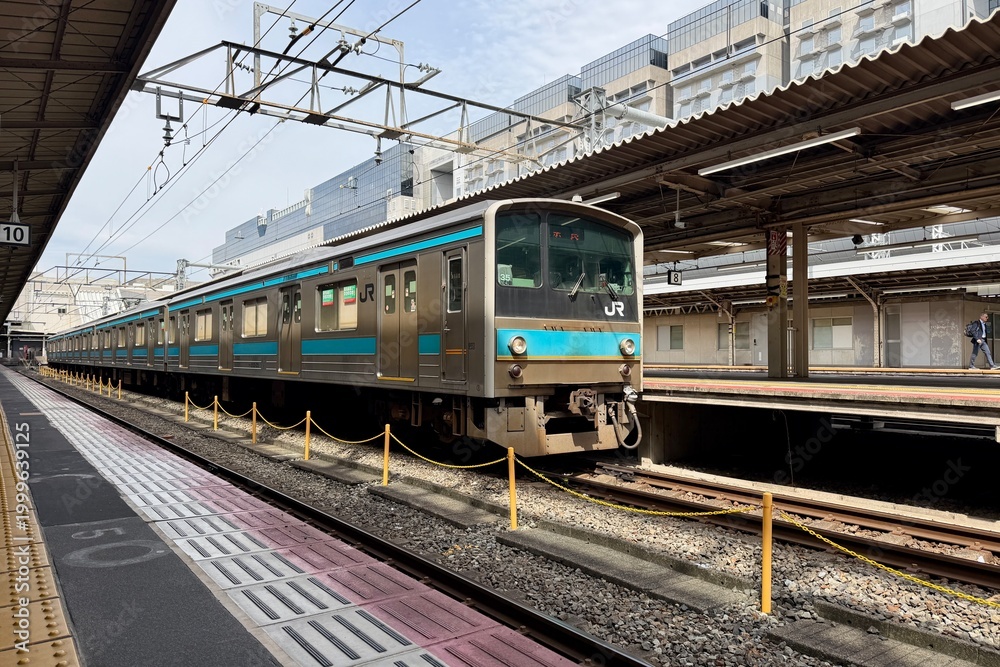 Fototapeta premium Kyoto, Japan - April 10, 2026: Train entering the platform at Kyoto Station, Japan Railways, modern metro and rail infrastructure with dynamic urban travel atmosphere.