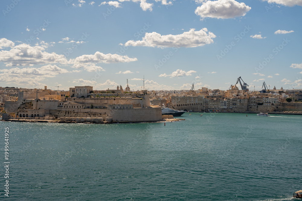 Fototapeta premium Horizontal panoramic view of Fort St. Angelo and luxury yachts in the Grand Harbour. Historic architecture of Birgu, Malta.