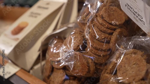Packaged cookies displayed in a store, showcasing layers of biscuits in transparent wrapping with branding visible on the packaging