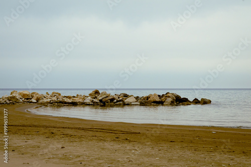 Fotografie Tranquil Zapalo Beach with rock breakwater and sandy shore in Limassol, Cyprus