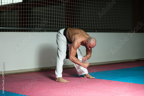 Schilderij op canvas Karate Man In A Kimono Limbering Up